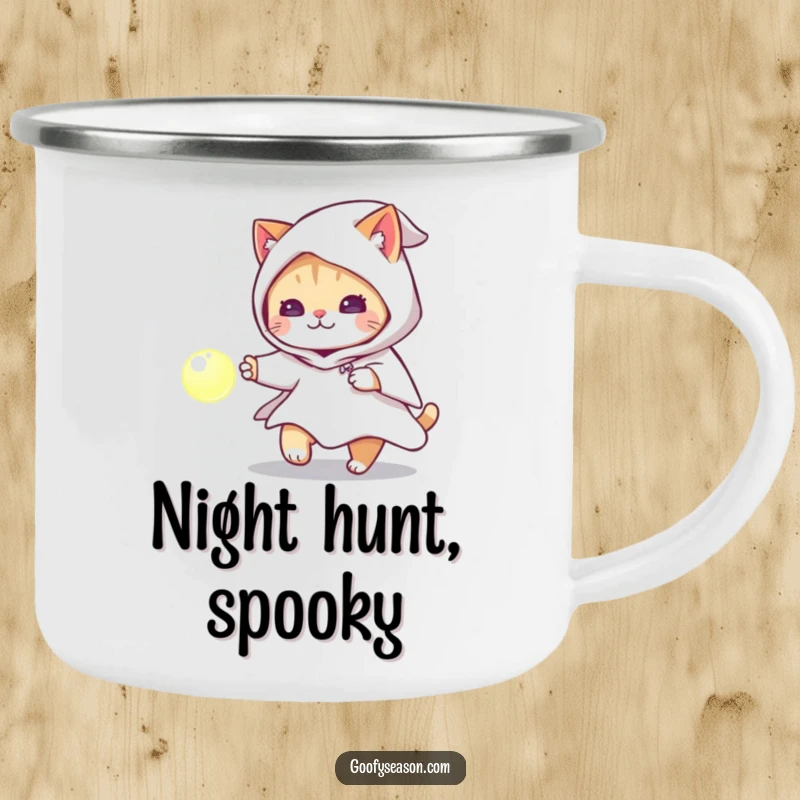 Funny cat wearing a ghost costume chasing a glowing orb on a rugged camping mug, for spooky outdoor fun.