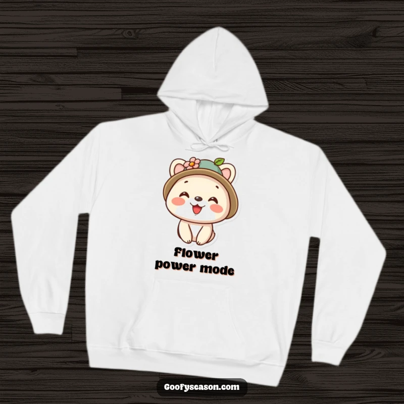 Funny kawaii animal character sporting a tiny floral-adorned hat and a wide, happy smile on a warm hoodie.